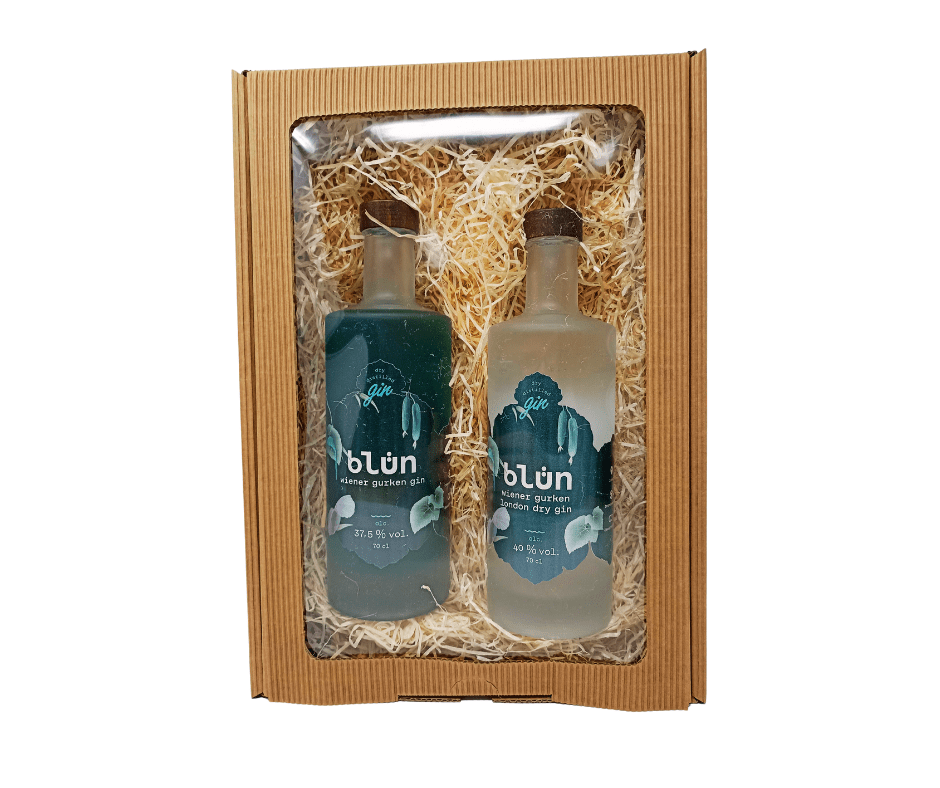 Gift set with two 700ml bottles of blue and clear gin in a cardboard box with straw filling.