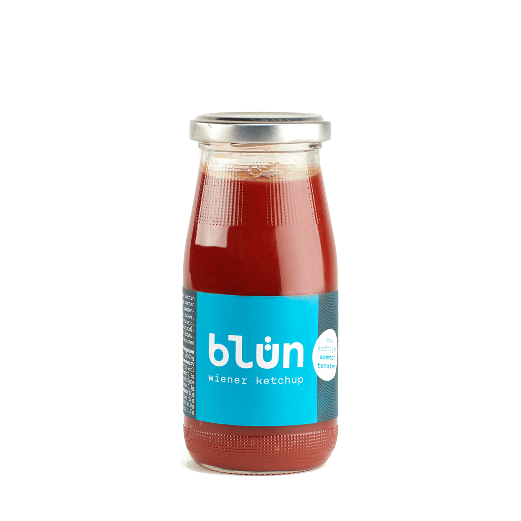 Glass bottle of blün Wiener ketchup with blue label and silver cap.